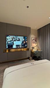 a hotel room with a bed and a flat screen tv at فندق جولدن نيو سمارت لاكجري - Golden New Smart Hoteluxury in Abha