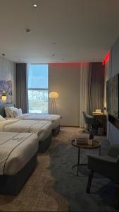 a hotel room with three beds and a television at فندق جولدن نيو سمارت لاكجري - Golden New Smart Hoteluxury in Abha