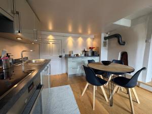 a small kitchen with a wooden table and chairs at Cosy duplex close to Verbier in Bruson