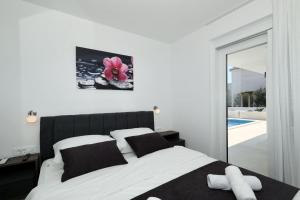 a bedroom with a white bed with a pink flower on the wall at Mariva in Vir +29 photos