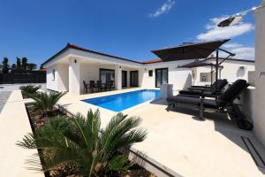 a villa with a swimming pool and an umbrella at Mariva in Vir