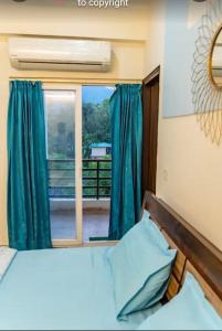 a bedroom with a bed and a window at The Huddle - Dawn in Dehradun