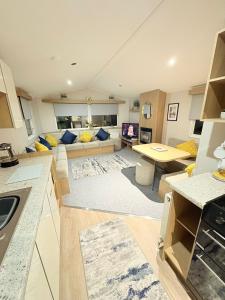 a kitchen and living room with a couch and a table at The Vacation Lyons Winkups Towyn in Kinmel Bay