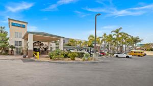 a parking lot in front of a hotel with palm trees at Oceanside, CA – Marina / Camp Pendleton in Oceanside