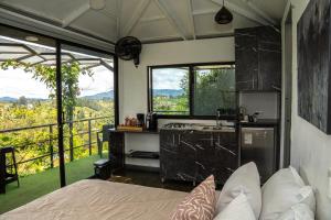 a bedroom with a bed and a kitchen with a view at Rocks Glamping - Guatapé, El Peñol in El Peñol