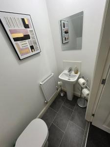 a bathroom with a white toilet and a sink at Modern spacious Home in Rhyl in Rhyl +5 photos