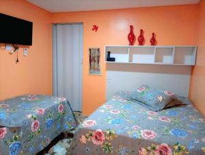 a bedroom with two beds and two vases on the wall at Pousada Opção I in Triunfo