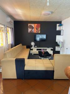 a living room with a couch and a tv at Ramachi apartments in Livingstone