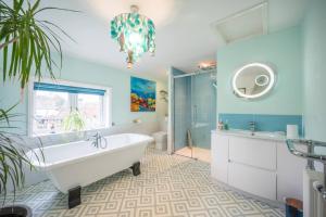 a bathroom with a tub and a shower and a sink at The Old Bakery, Wrentham in Wrentham +37 photos