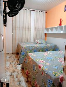 a bedroom with two beds with floral sheets at Pousada Opção I in Triunfo