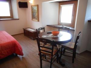 a room with a table and chairs and a bed at Le Petit Soleil in Saint-Christophe