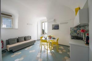a kitchen and a living room with a table and a couch at La mia casetta al mare in Minori