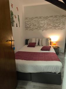 ein Schlafzimmer mit einem großen Bett und roten und weißen Kissen in der Unterkunft Chambre d'hôte près de Pairi Daiza Mons ENGYH house 1 in Lens + 21 Fotos