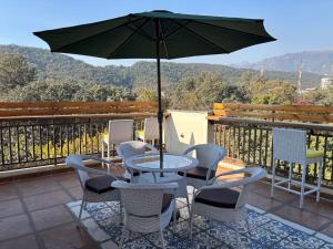 a table and chairs with an umbrella on a balcony at Golden Heights in Dehradun