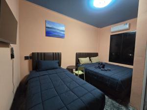 a bedroom with two beds and a window at โรงแรมเลทุ่งแล่น 109 in Ban Phru Ching (1)