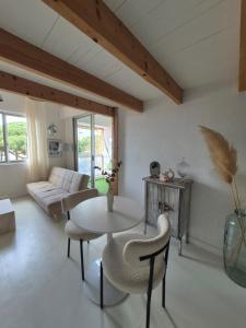 a living room with a table and a couch at Appartement avec piscine proche plages in Cap d'Agde