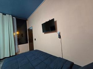a bedroom with a bed and a flat screen tv on the wall at โรงแรมเลทุ่งแล่น 109 in Ban Phru Ching (1)