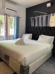 a large bed with a black headboard in a bedroom at Ramachi apartments in Livingstone