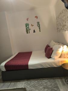 Ein Schlafzimmer mit einem Bett mit weißer Bettwäsche und Palmen an der Wand in der Unterkunft Chambre d'hôte près de Pairi Daiza Mons ENGYH house 1 in Lens