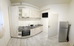 a kitchen with wooden cabinets and a refrigerator at Garsonieră O&M in Craiova