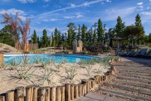 ein Schwimmbecken mit Stühlen und einem Holzzaun in der Unterkunft Waterstate Wellness hotel Goes in Goes
