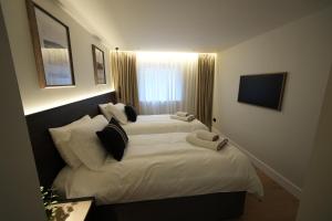 a bedroom with a bed with white sheets and pillows at 1st Floor Luxury 2-Bed Apt Sleeps 6 in St. Andrews