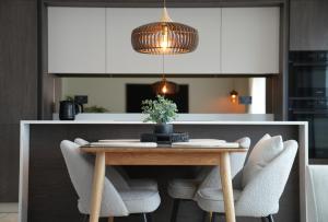a dining room table with chairs and a pendant light at 1st Floor Luxury 2-Bed Apt Sleeps 6 in St. Andrews