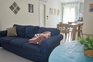 a blue couch in a living room with a table at La Casa di Zefiro in Santa Flavia +59 photos