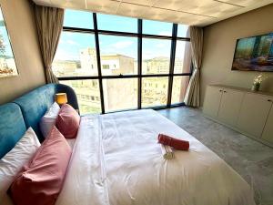 a large bed in a room with a large window at Studio luxueux avec vue panoramique sur le centre ville in Fez