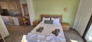 a bedroom with a large bed and a kitchen at Petrino 2 by Vasileia in Sarti
