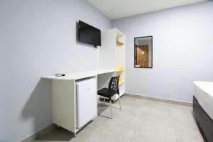 a white room with a desk and a chair at Pousada Recanto do Sol BF in Baía Formosa