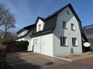 a white house with a black roof at Gästehaus Alexandra in Cuxhaven