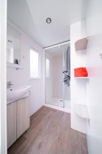 a white bathroom with a sink and a shower at Camping LANDAE in Ondres
