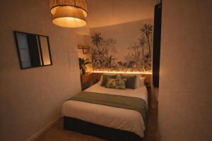 a bedroom with a large bed with a light on it at MRODBNB - Appart Neuf - Aperçu Mer - 25m Plage & Resto - Ciné - Cheminée - Popcorn in Cancale