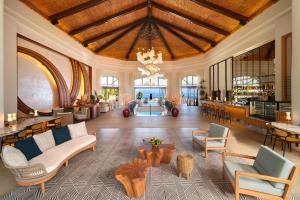 a lobby with chairs and tables and a chandelier at Hilton Hotel Tahiti in Papeete
