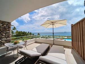 a balcony with a table and chairs and a view of the ocean at Hilton Hotel Tahiti in Papeete