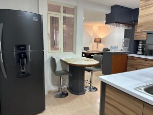 a kitchen with a black refrigerator and a table at Casa Homero 23 in Morelia