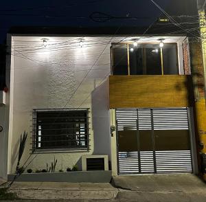 a white house with a door and a window at Casa Homero 23 in Morelia