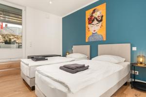 two beds in a room with a painting on the wall at HOMEBASE - Design Lofts am Schloss in Montabaur