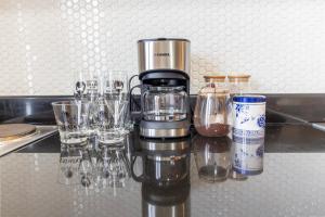 a coffee maker sitting on top of a counter with glasses at BreezeVista Getaway in Kaybagal +2 photos