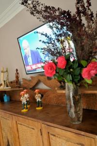 a table with a vase of flowers and a tv at Departamento 1ph in Miramar