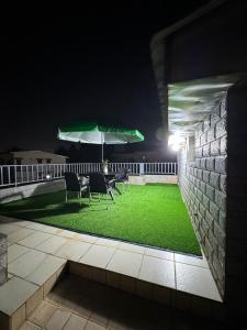a patio with chairs and an umbrella at night at Afraah guest house in Yaoundé
