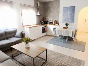 a living room with a table and a kitchen at Muy acogedor, a 5 min a pie del centro, Cama 1'60, Wifi y Netflix in San Vicente de la Barquera