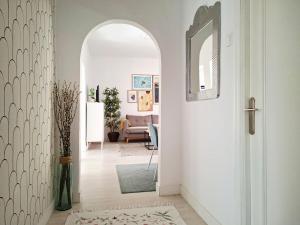 a hallway with a white door with a mirror at Muy acogedor, a 5 min a pie del centro, Cama 1'60, Wifi y Netflix in San Vicente de la Barquera