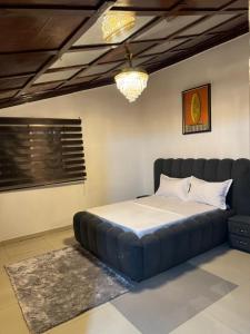 a large bed in a room with a blue couch at Afraah guest house in Yaoundé