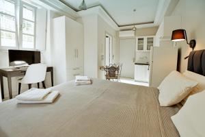 a white bedroom with a bed with two towels on it at Earino apartments in Hydra