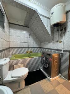 a bathroom with a toilet and a washing machine at Afraah guest house in Yaoundé +18 photos