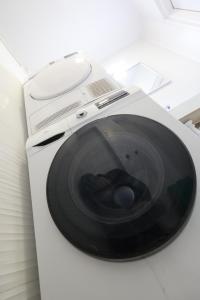 a white washing machine with a black door at Bright & Sunny Studio in Sesvete +9 photos