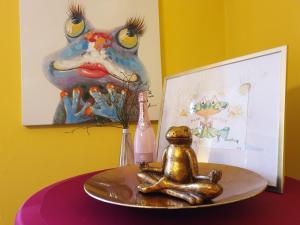 a statue of a frog sitting on a table with a bottle at Pension Max in Senftenberg +76 photos