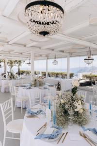 a wedding reception with white tables and chairs and a chandelier at Santorini Gem in Órmos Athiniós
